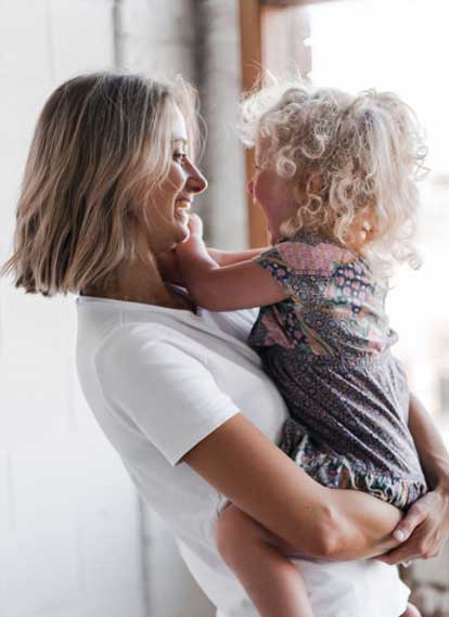 Fitnest Mama founder Kath Baquie holding her daughter